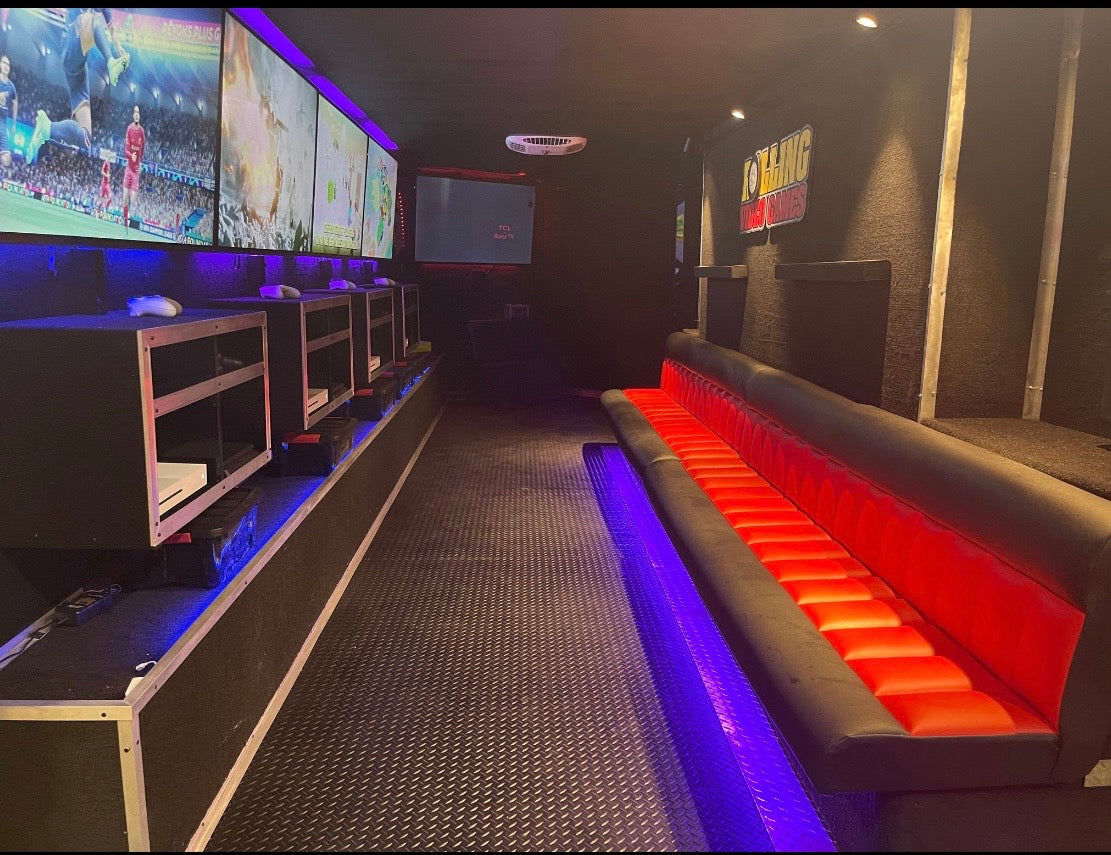 Inside the Rolling Video Games trailer: wall of screens and lounge seating